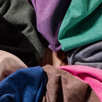 Close-up of folded fabric in various colors arranged in a circular pattern.