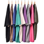 Row of colorful sweatshirts hanging on wooden hangers against a gray background