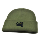 Green beanie with a black cat embroidery on a white background