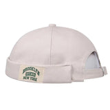 Beige cap with a 'Brooklyn New York' patch on a white background