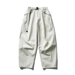 Beige Parachute cargo pants flat lay highlighting zippered pockets and clip buckle waist closure