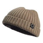 Beige knit beanie with a smiley face logo on a white background
