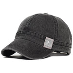Black Acid wash short brim baseball cap — worn angled view
