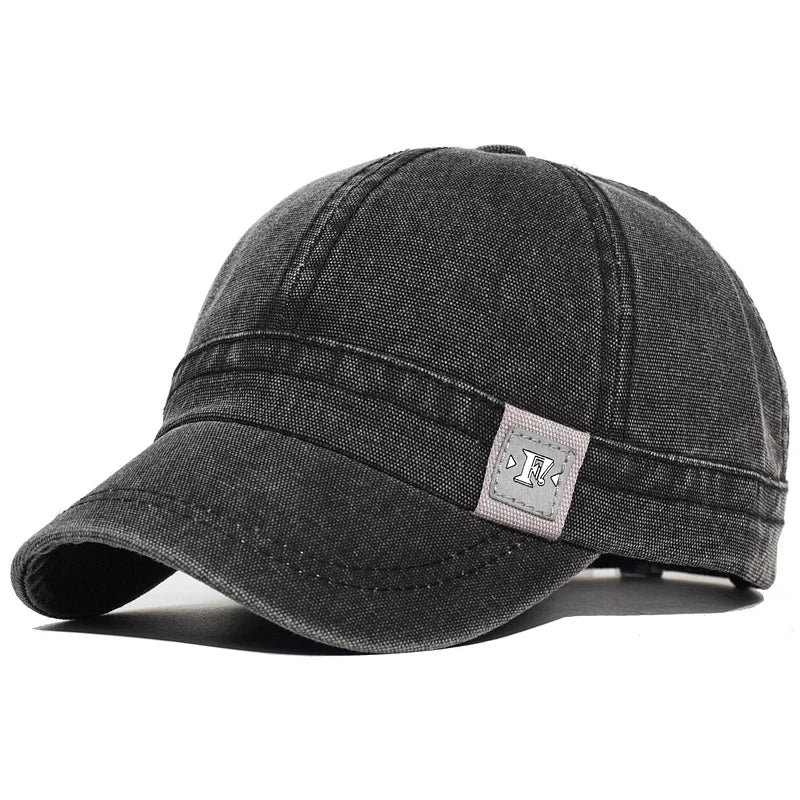 Black Acid wash short brim baseball cap — worn angled view