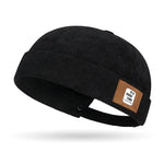 Black Brimless corduroy docker cap worn on model, side view
