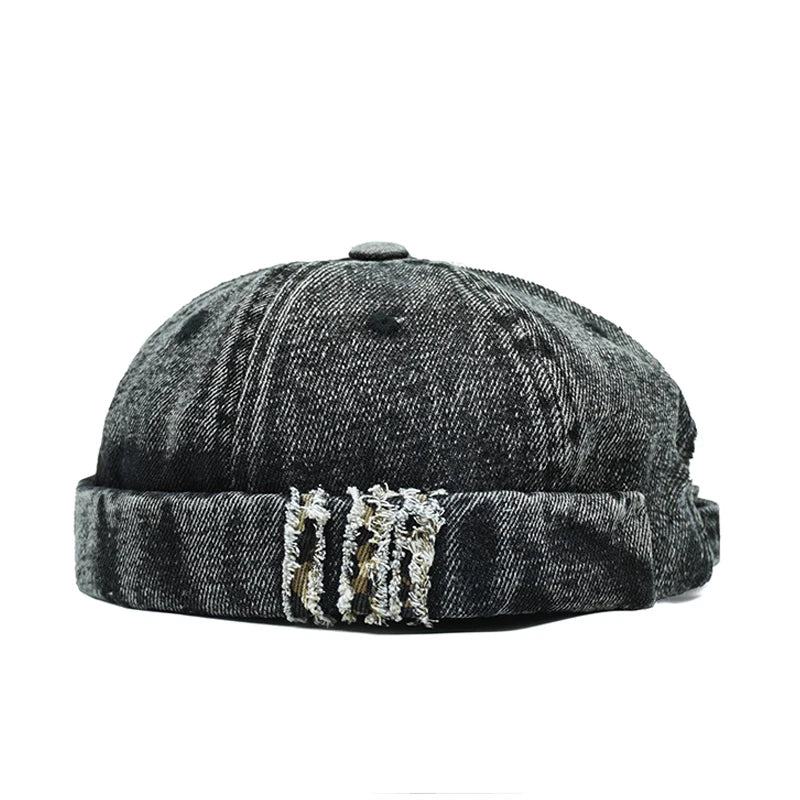 Black denim cap with distressed details on a white background