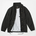 Black Nylon coach jacket laid flat open showing snap buttons and white lining