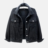 Black Close-up on-model detail of blue oversized denim jacket showing collar and button closure