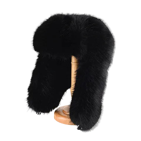 Black fur hat on a wooden stand against a white background