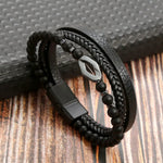 Black Rhombus Beaded leather layered bracelet resting on wood surface showing diamond charm and braided strand
