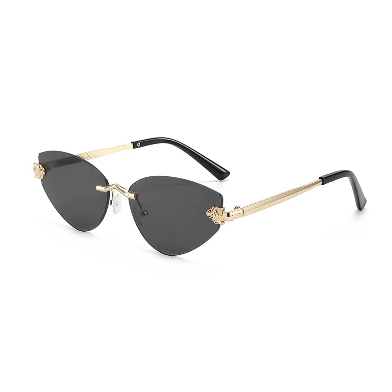 Black Rimless cat eye sunglasses shown at a side angle flat lay with gold metal temples
