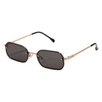 Sunglasses with gold frame and black lenses on a light beige background