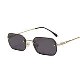 Sunglasses with gold frame and black lenses on a light gray background, branded 'Ah-Mee'.