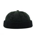 Black knit beanie with textured pattern on a white background
