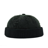 Black knit beanie with textured pattern on a white background