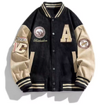 Black varsity jacket with beige sleeves and multiple patches on a white background