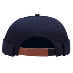 Brimless skullcap with letter patch detail, side profile view