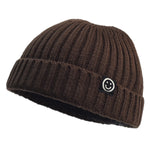 Brown knit beanie with a smiley face patch on a white background