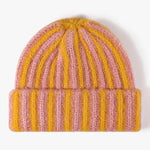 Knitted beanie with pink and yellow stripes on a white background