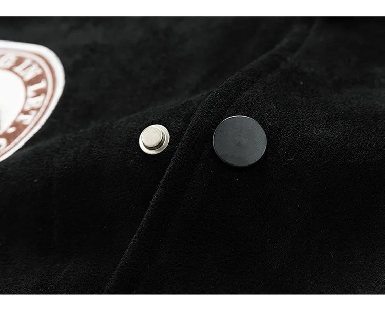Close-up of a black jacket with buttons and a logo on a dark background