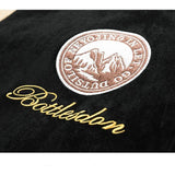 Close-up of a black surface with an embroidered logo and text.