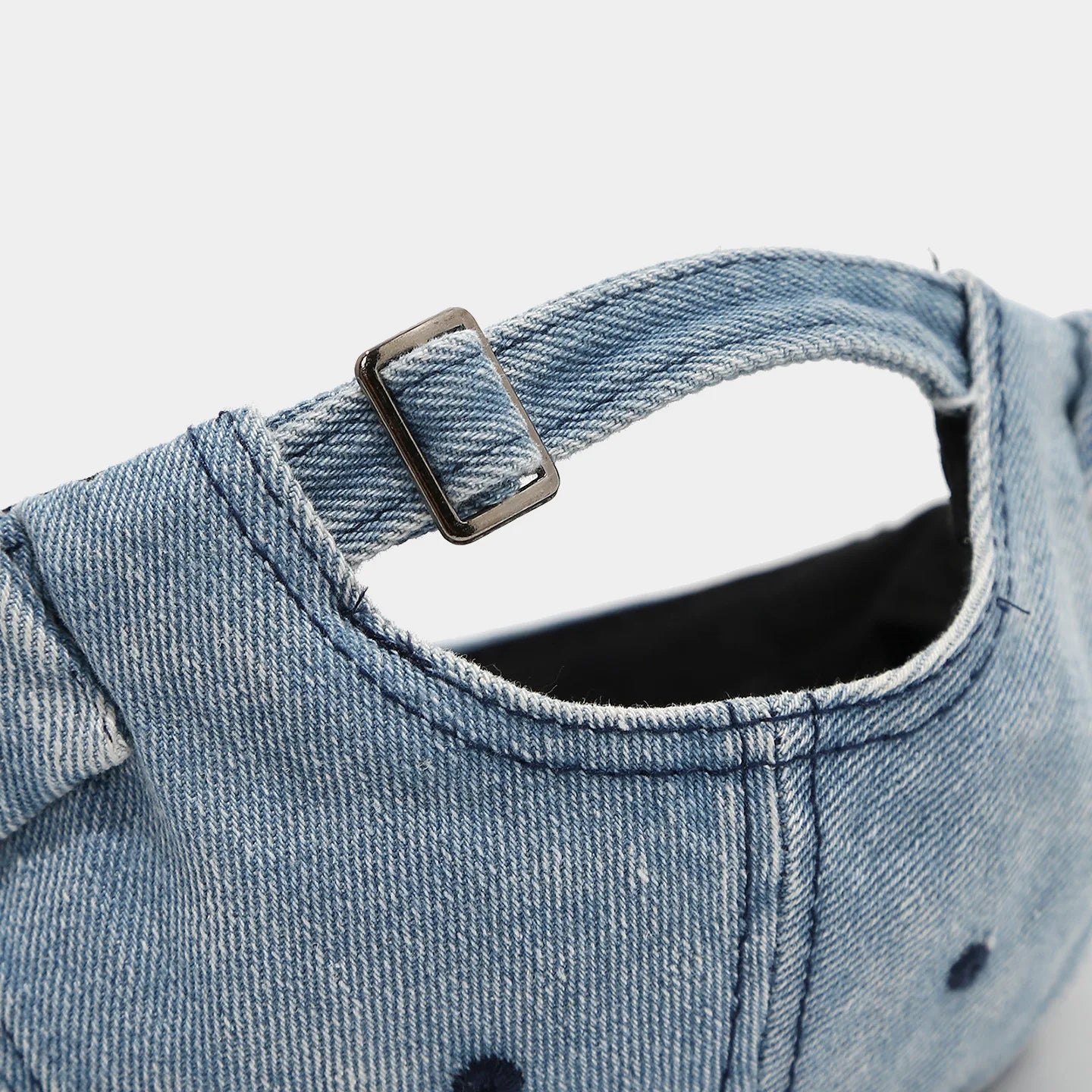 Distressed denim docker cap worn, side view