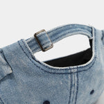 Distressed denim docker cap worn, side view