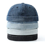 Stack of denim hats in various shades on a white background