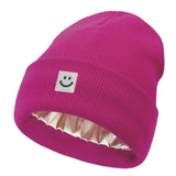 Fuchsia beanie with a smiley face label on a white background