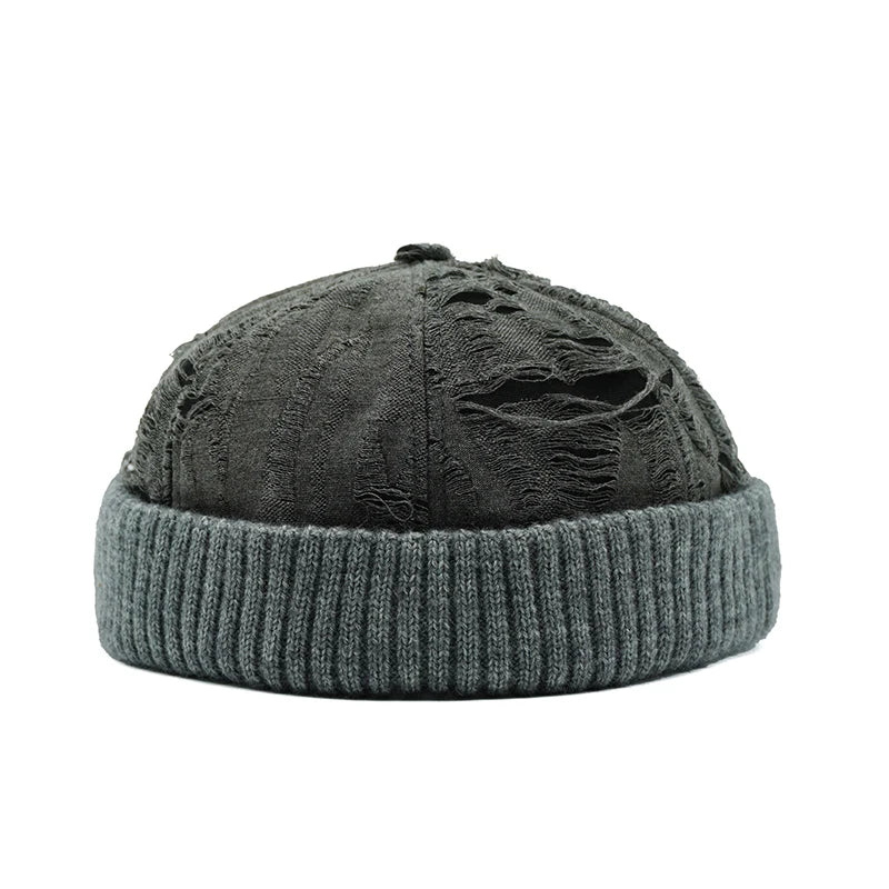 Gray beanie with distressed top on a white background