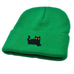 Green beanie with a black cat design on a white background