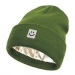 Green beanie with a smiley face logo on a white background