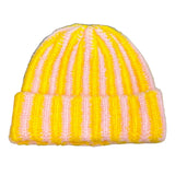 Striped yellow and pink beanie on a textured surface