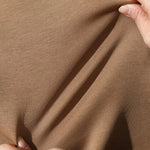 Khaki Crewneck sweatshirt fabric pinched between fingers to show fleece texture