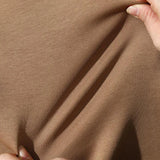 Khaki Crewneck sweatshirt fabric pinched between fingers to show fleece texture
