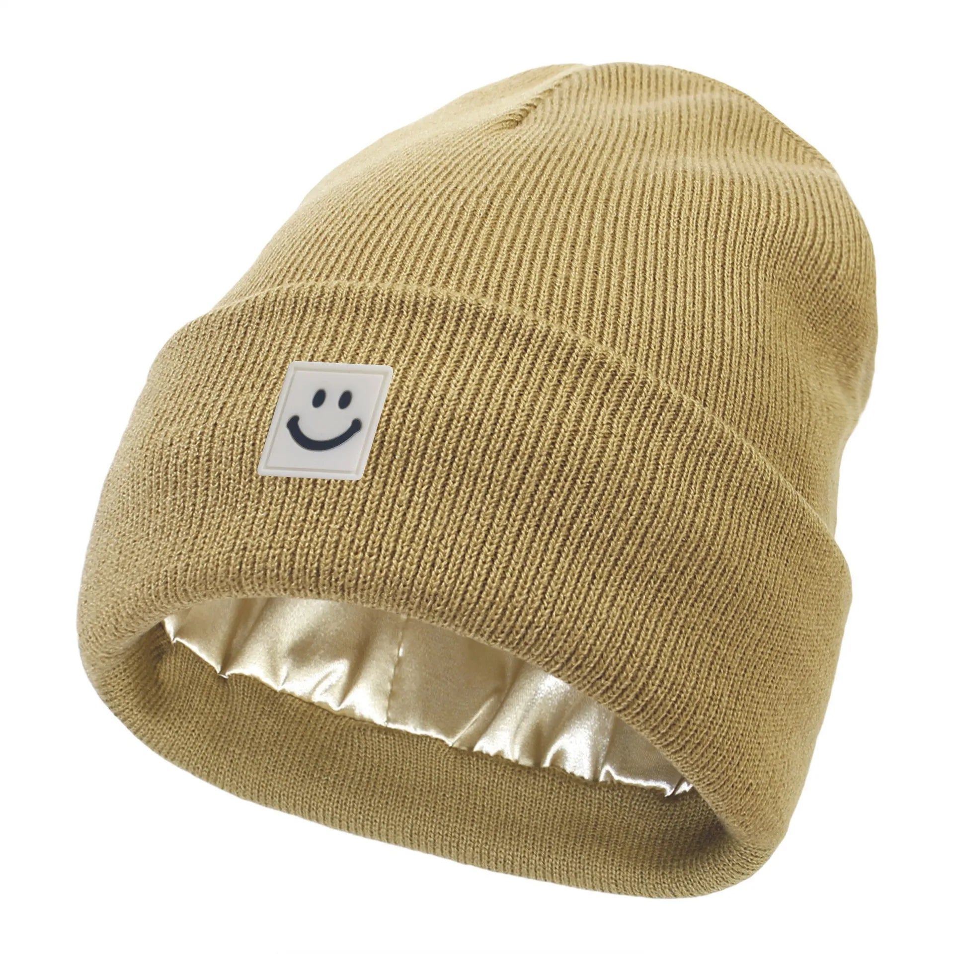 Khaki knit beanie with a smiley face label on a white background