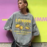 Close-up detail of lemon graphic print and vintage wash texture on cotton tee