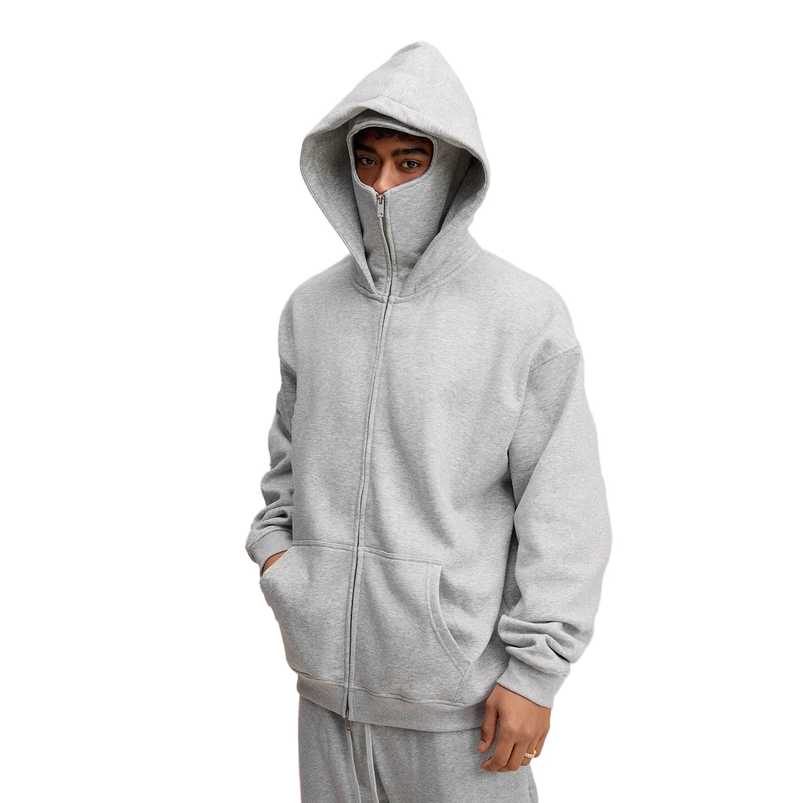 Person wearing a gray hoodie on a beige background