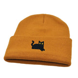 Mustard yellow beanie with a black cat embroidery on a white background