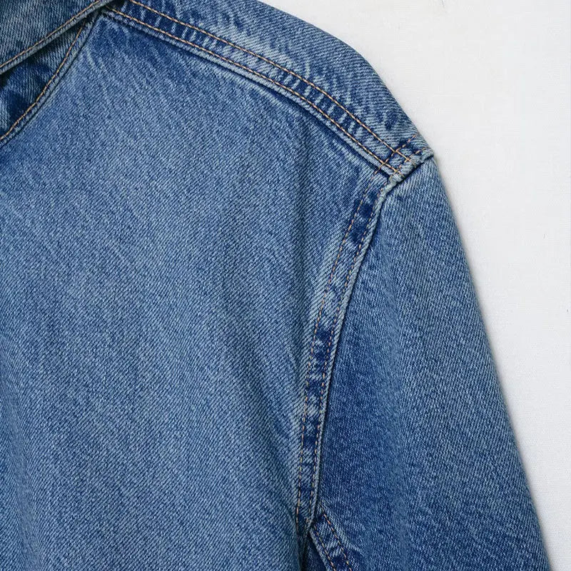 Close-up of turtleneck collar and vintage wash texture on women's oversized denim jacket