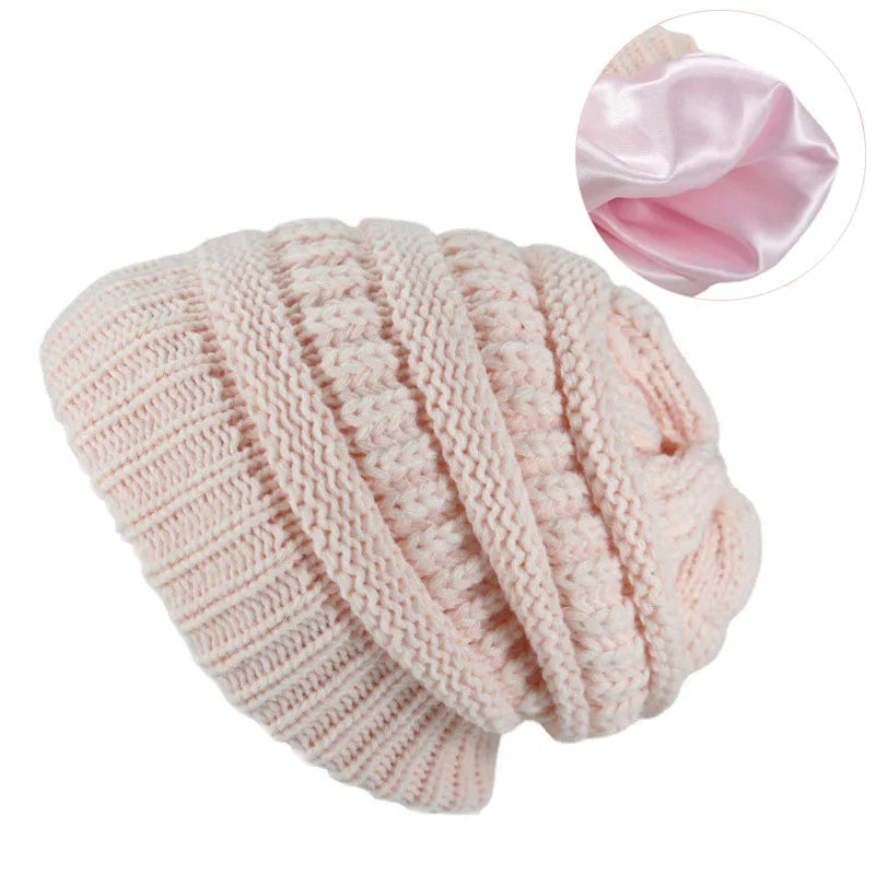 Pink knitted beanie with satin lining on a white background