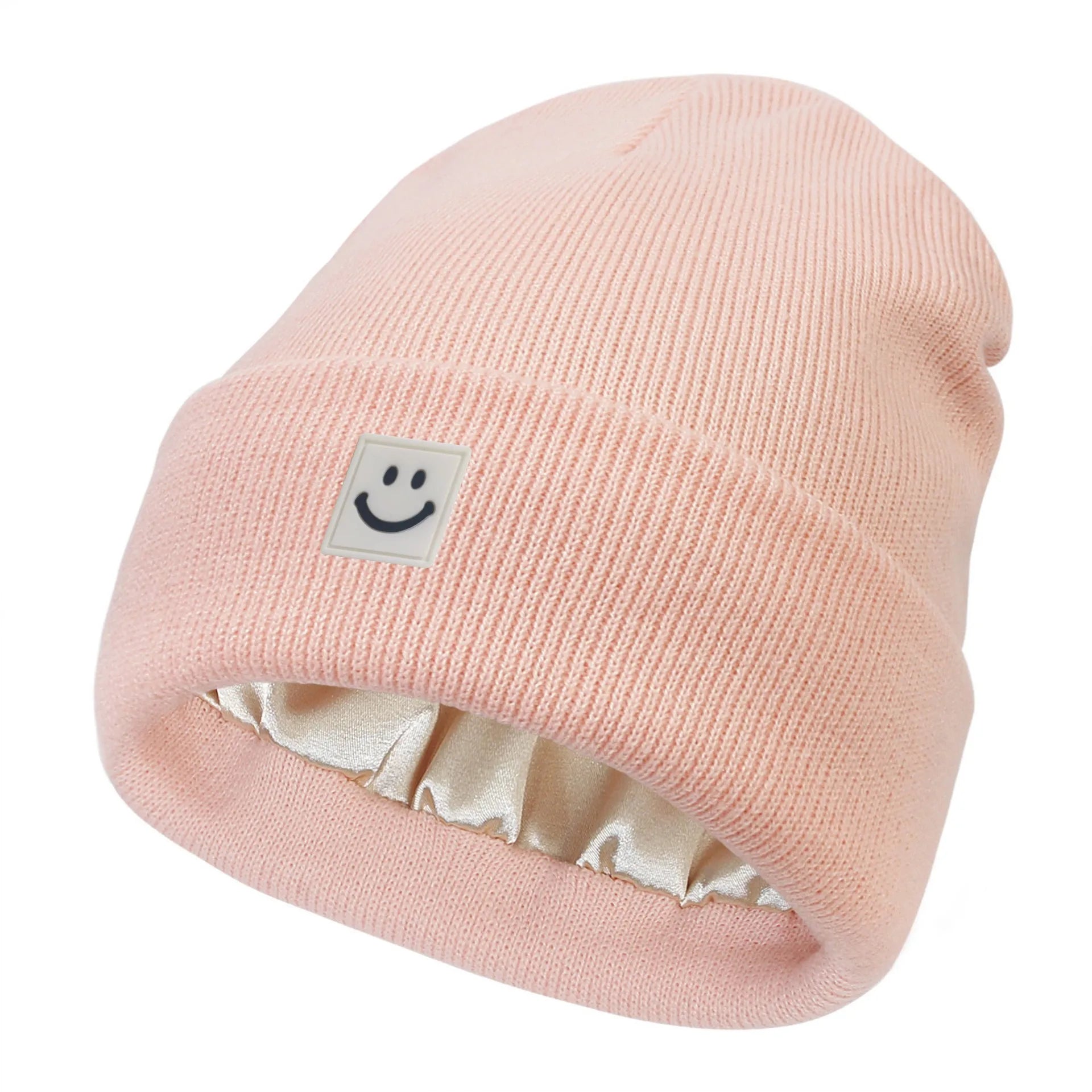 Pink beanie with a smiley face label on a white background