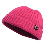 Pink knit beanie with a smiley face logo on a white background