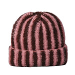 Knitted beanie with pink and brown stripes on a gray background