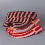 Stack of colorful knitted items on a gray background