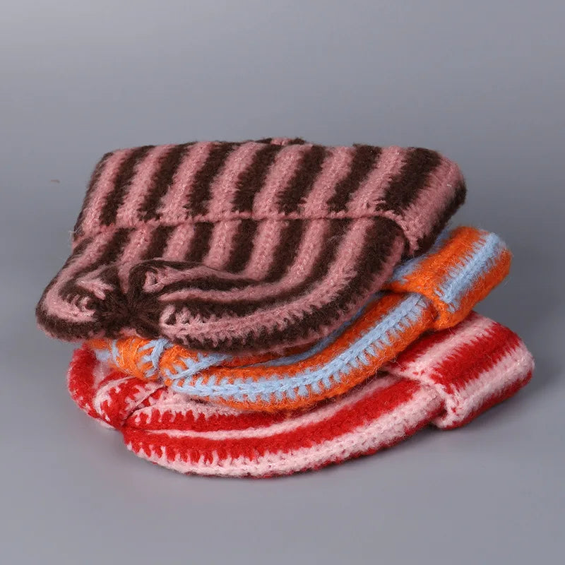 Stack of colorful knitted items on a gray background