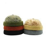 Two beanies in green, orange, and black, and beige, gray, and black on a white background with BOCCA branding.