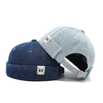 Two denim baseball caps, one blue and one gray, on a white background.