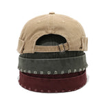 Stack of three baseball caps in beige, green, and maroon on a white background