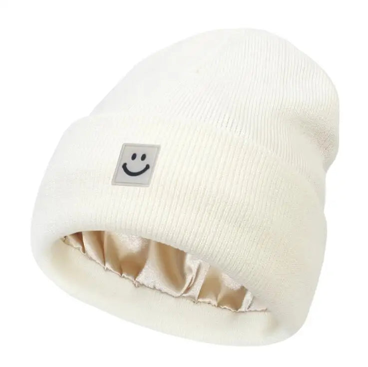 White beanie with a smiley face label on a white background